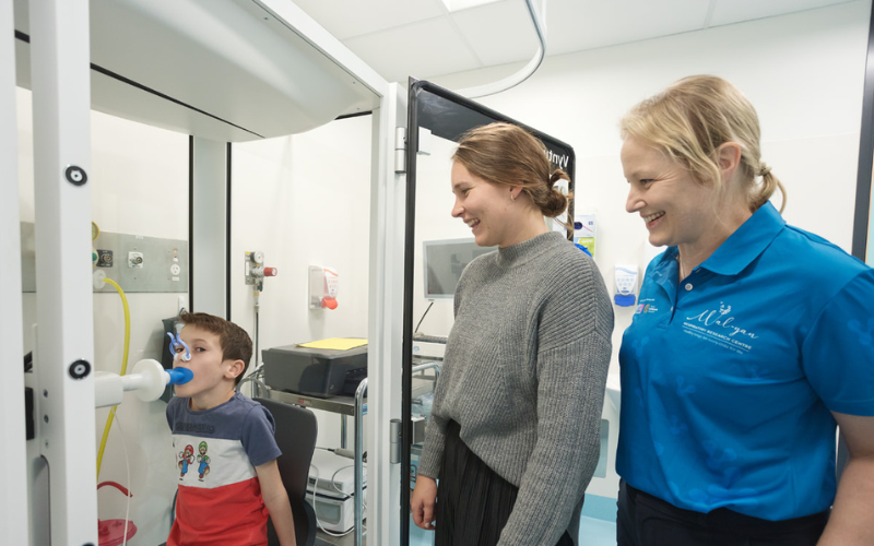 seven-year-old Pierce Brazier undertaking a lung function test with Research Assistant Tiffany Bradshaw (left) and Associate Professor Shannon Simpson (right). 